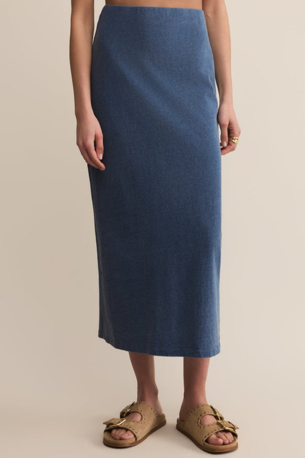 Person wearing a blue skirt on a beige background