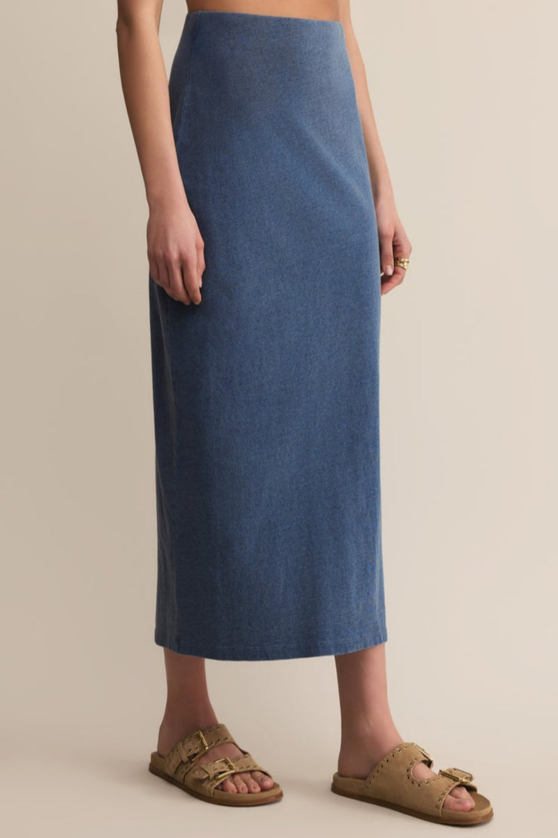 Person wearing a blue skirt on a beige background