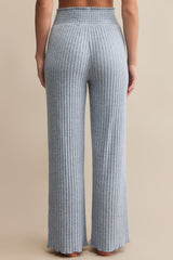 Blue ribbed pants worn by a person on a beige background