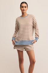 Woman wearing a striped sweater and shorts on a beige background