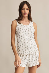 Woman wearing a sleeveless top and shorts set with a subtle pattern on a beige background