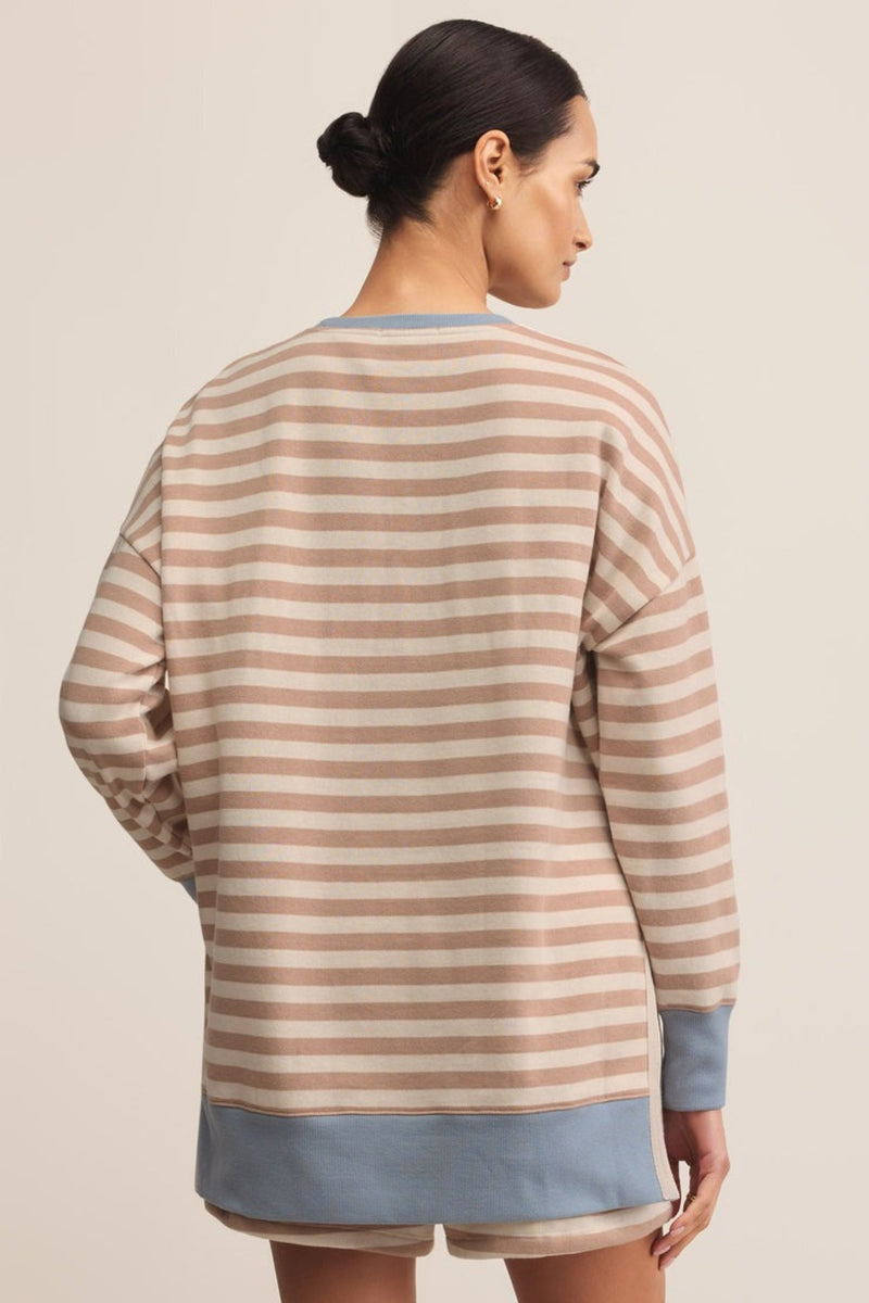 Woman wearing a striped sweater and shorts on a beige background