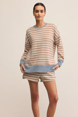 Woman wearing a striped sweater and shorts on a beige background