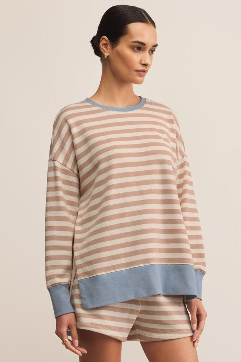 Woman wearing a striped sweater and shorts set on a beige background