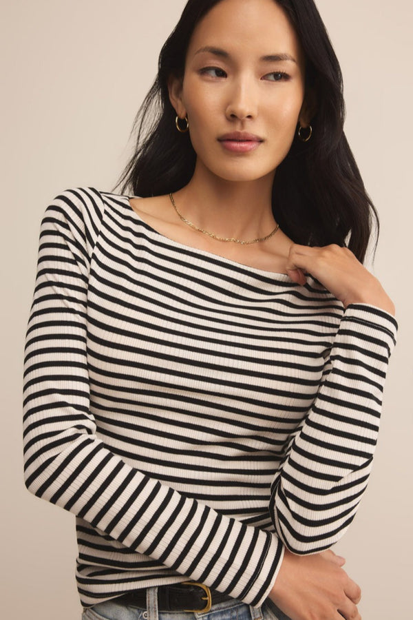 Woman wearing a black and white striped sweater against a beige background