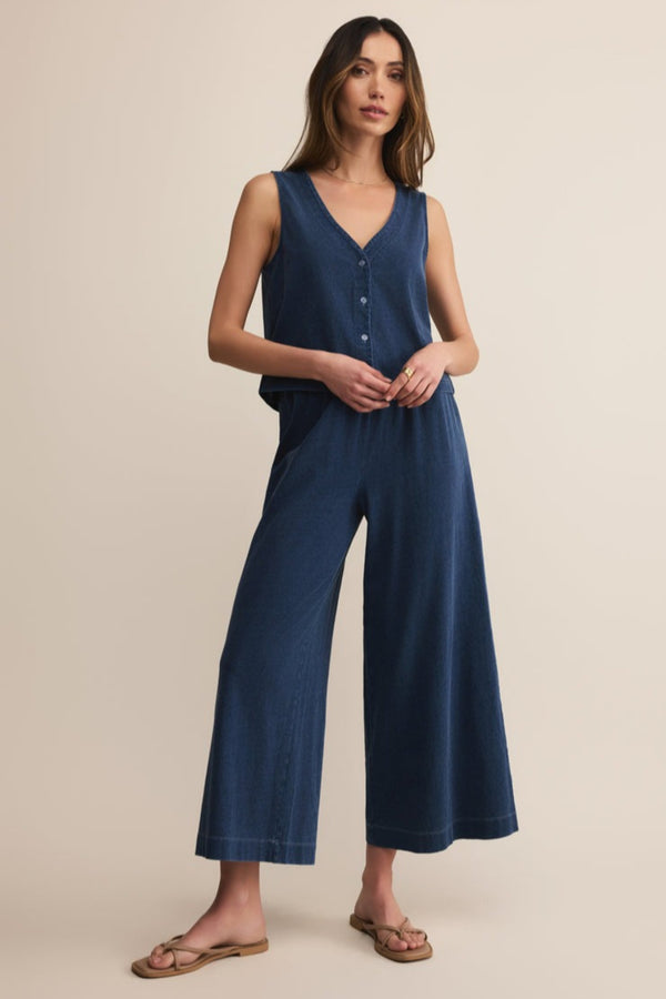Woman wearing a blue jumpsuit on a beige background