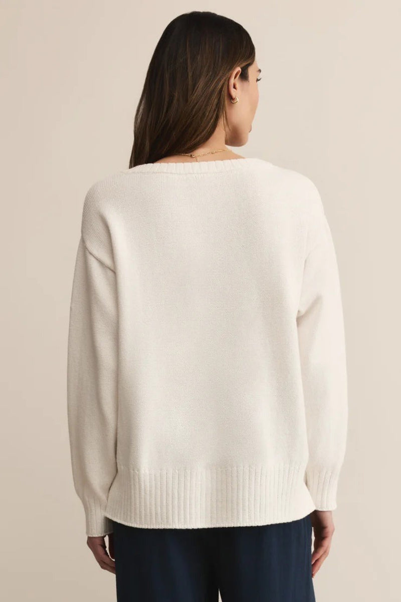 Person wearing a white sweater on a beige background