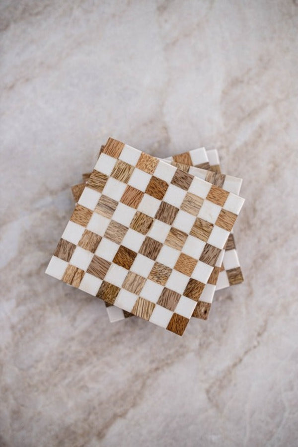 Checkerboard patterned coasters made of wood and white resin.