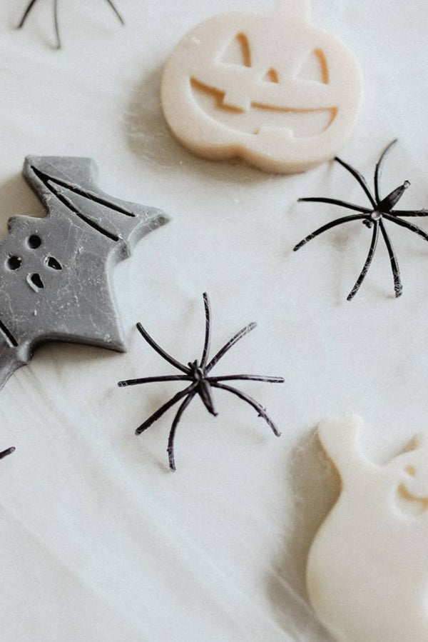 Halloween-themed soaps including a bat, spider, and ghost on a white background.