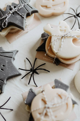 Halloween-themed cookies with decorative elements on a white surface