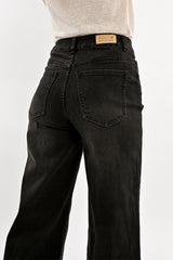 Black jeans with a visible brand label on a white background