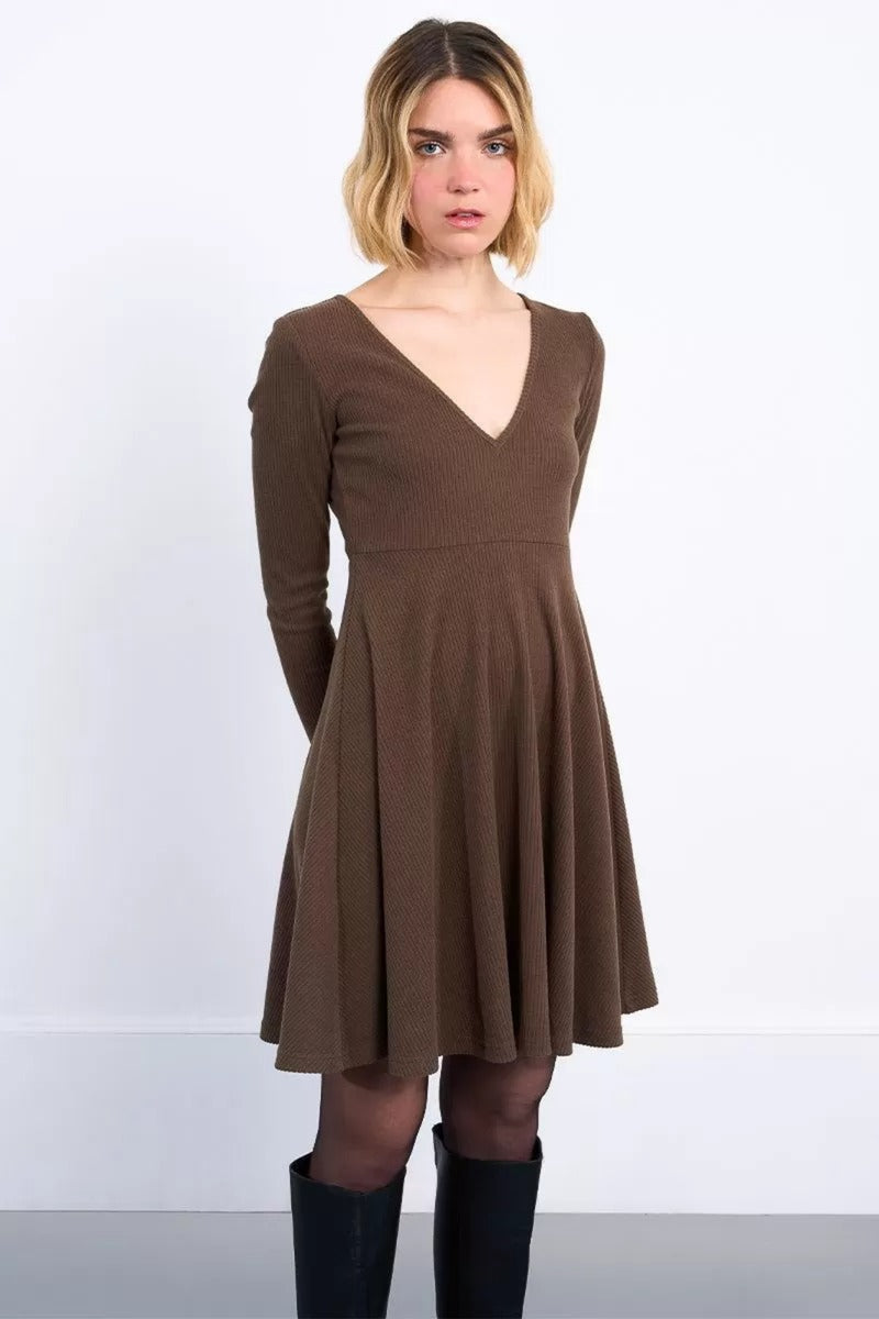 Woman wearing a brown dress with long sleeves on a white background