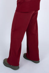 Burgundy pants worn by a person on a white background
