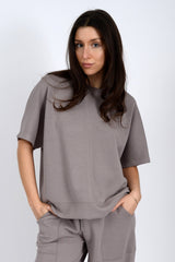 Woman wearing a gray outfit against a white background
