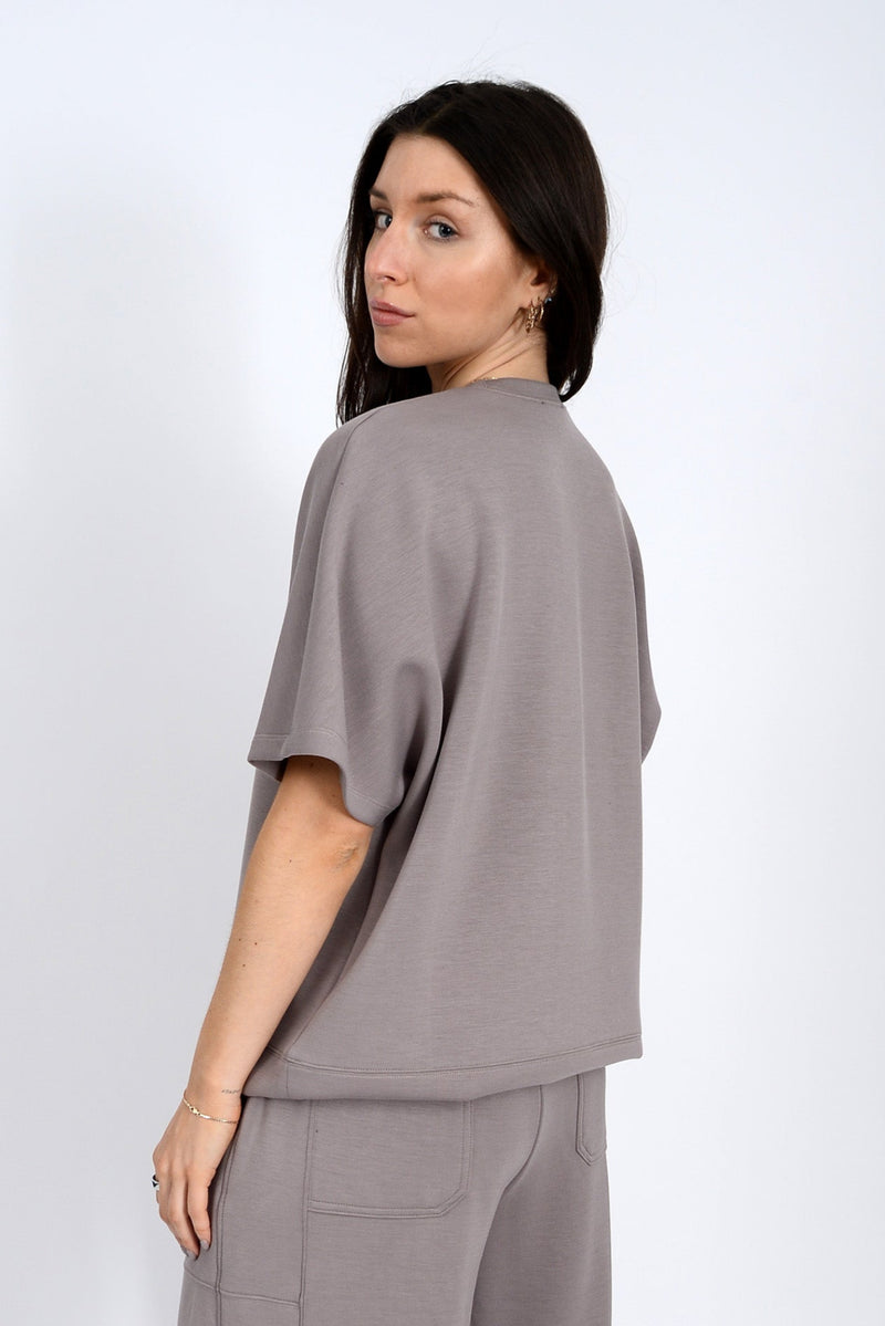 Woman wearing a gray outfit against a white background