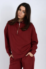 Woman wearing a red tracksuit against a white background