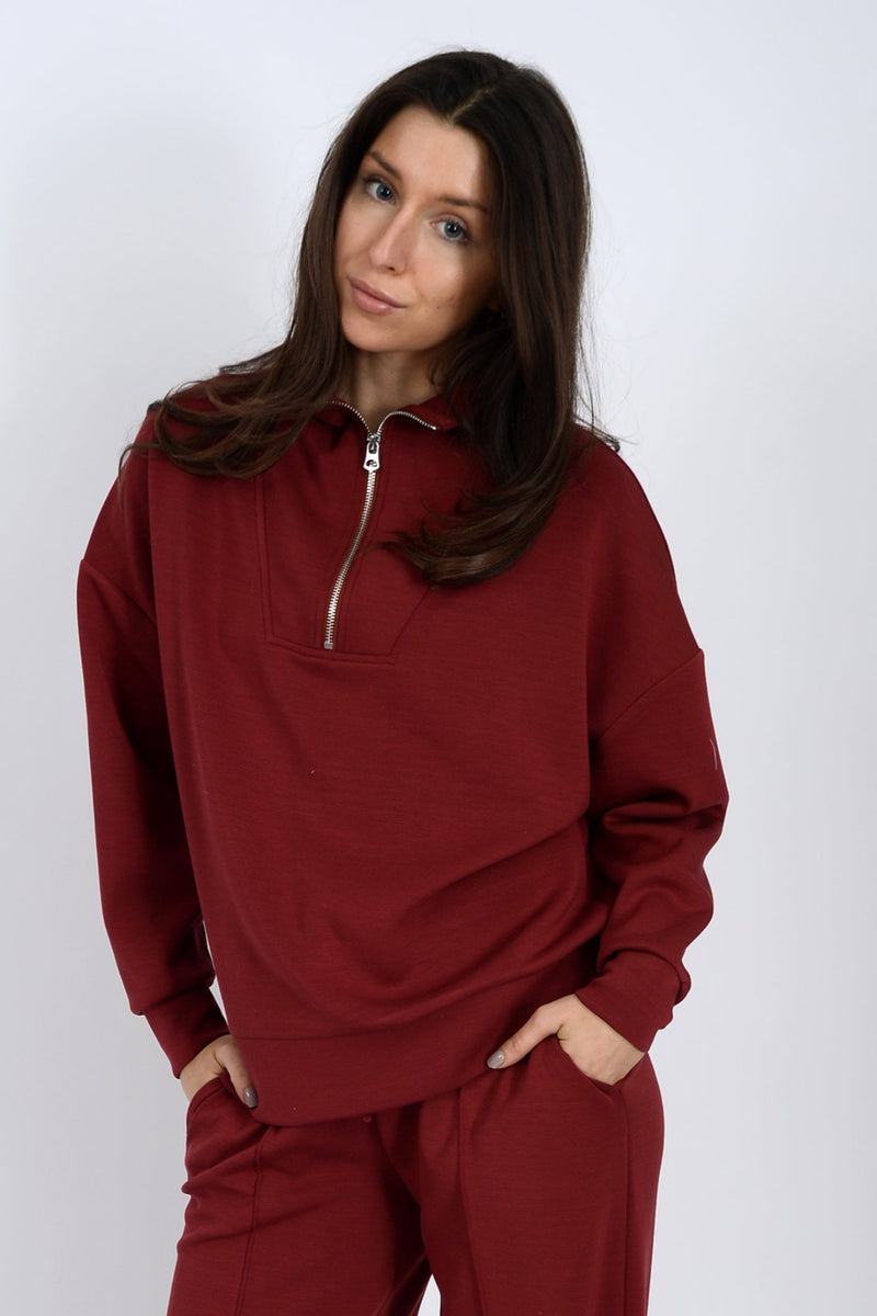 Woman wearing a red tracksuit against a white background