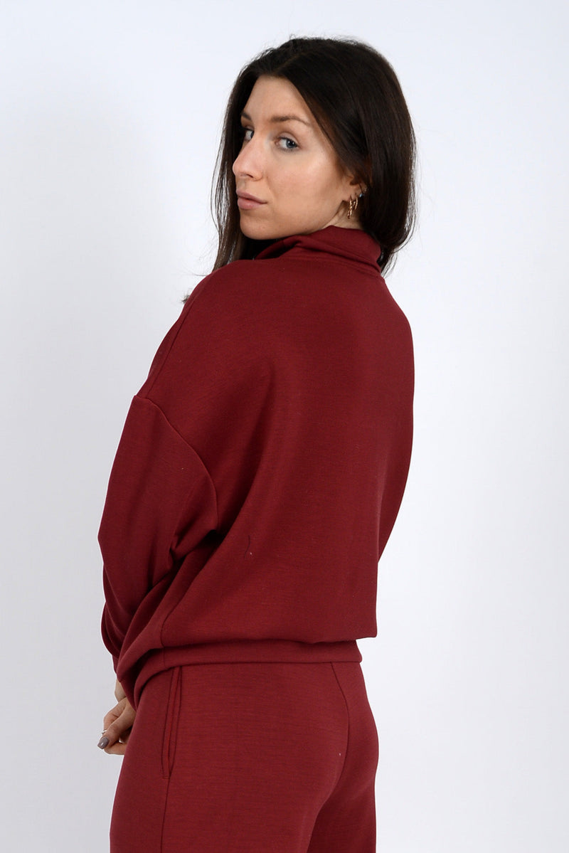 Woman wearing a burgundy outfit on a white background