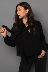 Woman wearing a black outfit against a gray background